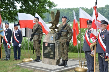 Na zdjęciu znajduje się pomnik poległych pilotów oraz żołnierze pełniący wartę honorową wraz z pocztami sztandarowymi